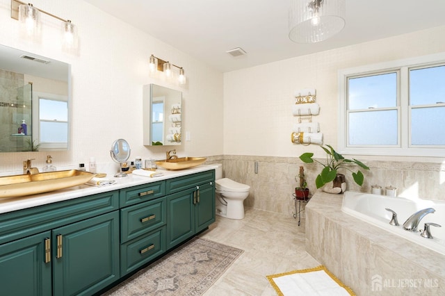 bathroom with a shower with door, toilet, a garden tub, double vanity, and a sink