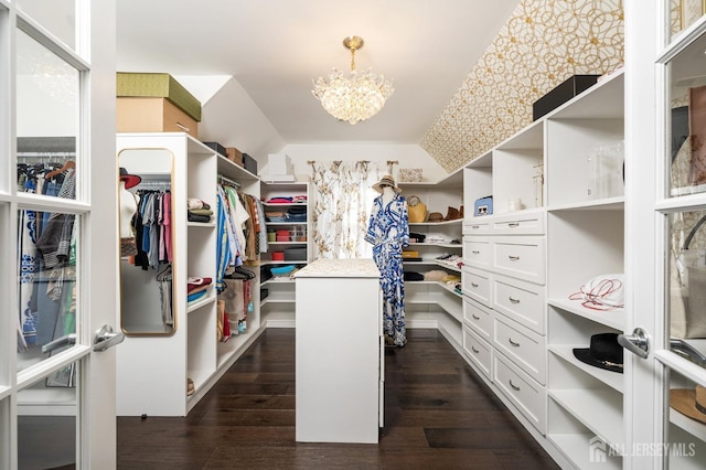 spacious closet featuring a chandelier and dark wood-style floors