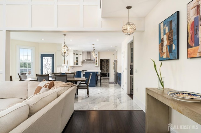 living room featuring recessed lighting, an inviting chandelier, light wood-type flooring, and baseboards