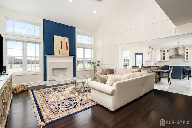 living room featuring a large fireplace, high vaulted ceiling, and dark wood-style flooring