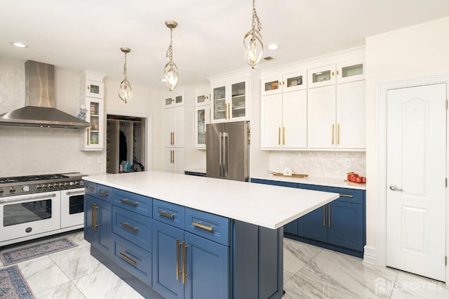 kitchen featuring blue cabinets, high quality appliances, marble finish floor, and wall chimney range hood