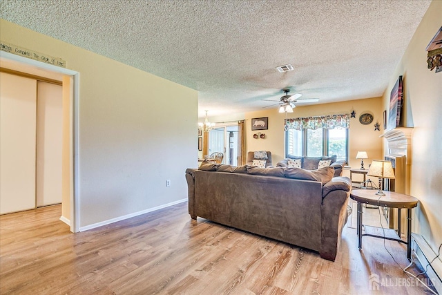 444 Dahlia Plz, Monroe, NJ 08831 - living room featuring baseboard heating, light wood finished floors, a textured ceiling, a ceiling fan, and a chandelier