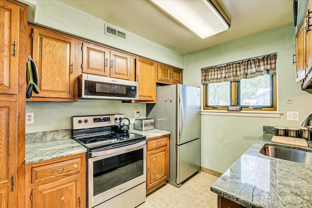 444 Dahlia Plz, Monroe, NJ 08831 - kitchen featuring appliances with stainless steel finishes, a sink, brown cabinetry, and light stone counters