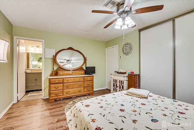 444 Dahlia Plz, Monroe, NJ 08831 - bedroom with light wood-type flooring, a closet, ceiling fan, connected bathroom, and a textured ceiling