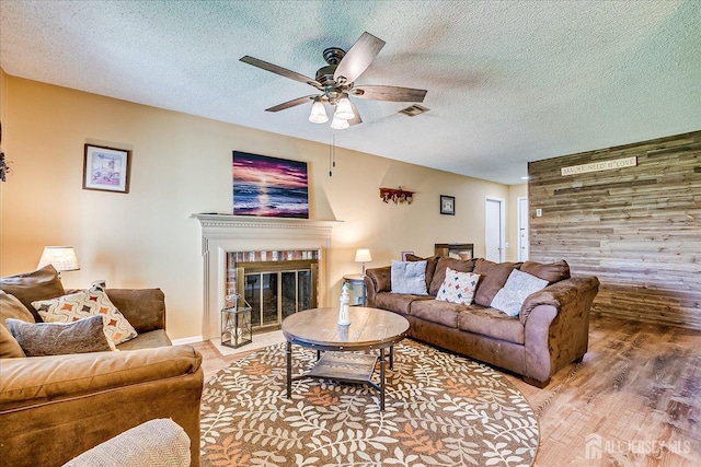 444 Dahlia Plz, Monroe, NJ 08831 - living room featuring a ceiling fan, wood finished floors, a textured ceiling, and a brick fireplace