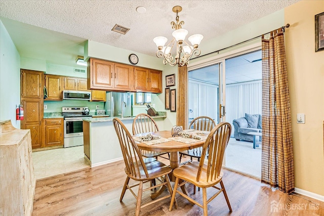 444 Dahlia Plz, Monroe, NJ 08831 - dining area featuring a chandelier, light wood-style flooring, and a textured ceiling