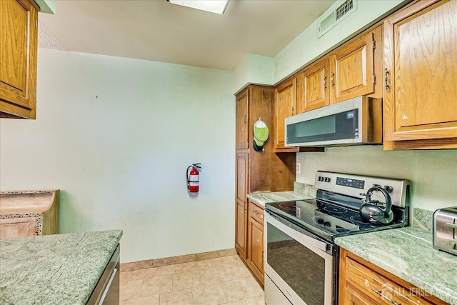 444 Dahlia Plz, Monroe, NJ 08831 - kitchen featuring stainless steel appliances, baseboards, brown cabinets, and light tile patterned floors