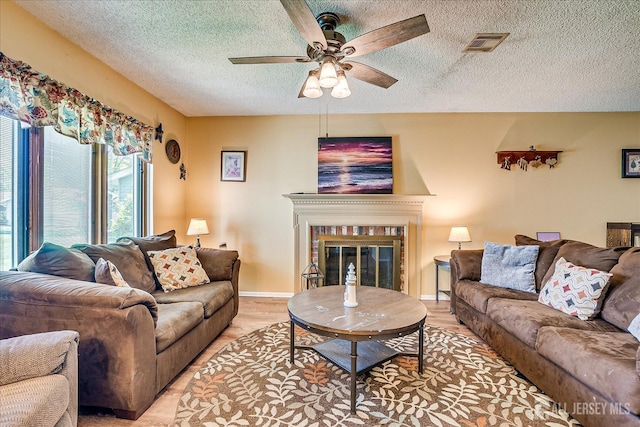 444 Dahlia Plz, Monroe, NJ 08831 - living room with a ceiling fan, a textured ceiling, a glass covered fireplace, light wood-style floors, and baseboards