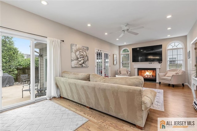 living room with a fireplace with flush hearth, ceiling fan, recessed lighting, and wood finished floors