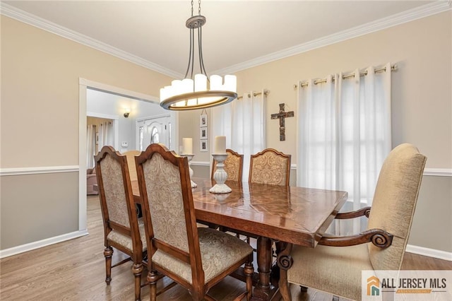 dining room featuring crown molding, wood finished floors, baseboards, and a chandelier