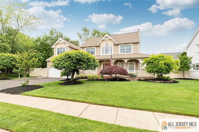 view of front of house featuring asphalt driveway, a garage, and covered porch