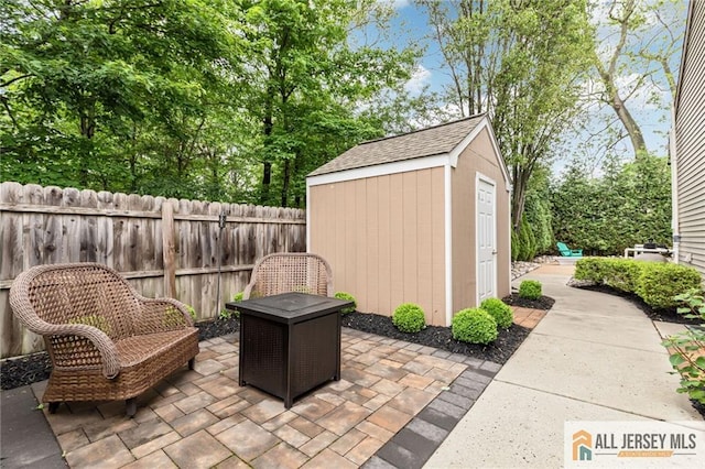 view of patio featuring a shed, an outbuilding, and fence