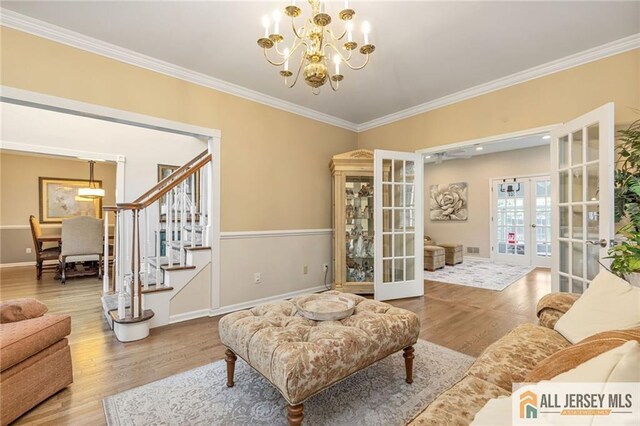 411 Arlington Ave, South Plainfield, NJ 07080 - living area with french doors, wood finished floors, stairs, ornamental molding, and a chandelier