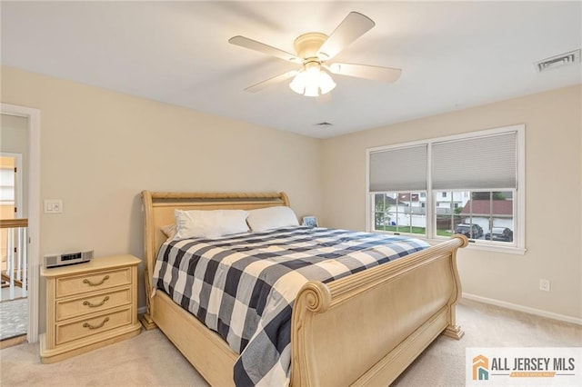 bedroom with light colored carpet, baseboards, and ceiling fan