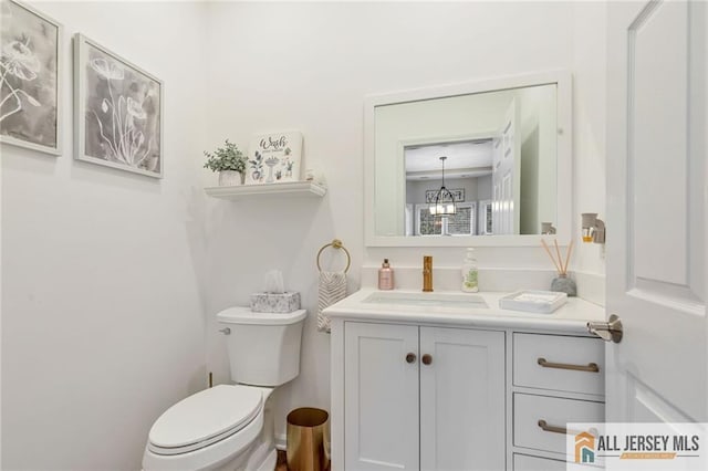 half bathroom featuring vanity and toilet