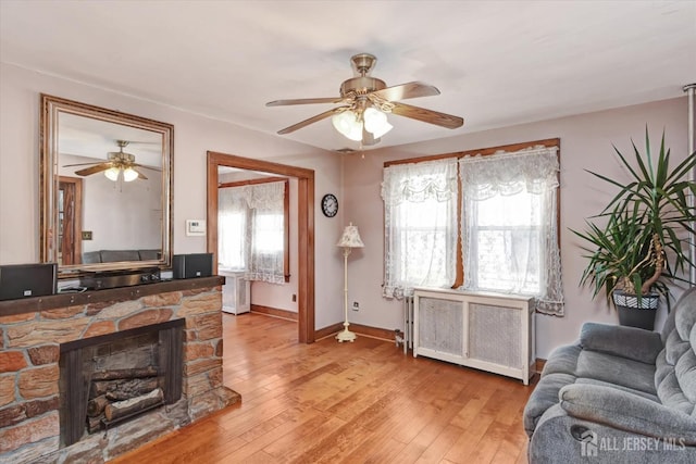 352 Parker Ave, South Amboy, NJ 08879 - living area featuring radiator, ceiling fan, light wood finished floors, baseboards, and a stone fireplace