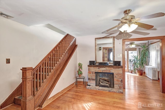 352 Parker Ave, South Amboy, NJ 08879 - living area featuring stairs, wood-type flooring, ceiling fan, a stone fireplace, and baseboards