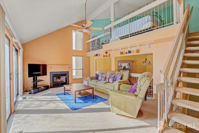 carpeted living room with track lighting, high vaulted ceiling, and ceiling fan