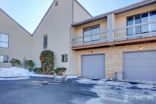 snow covered property featuring a garage