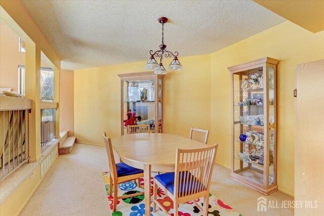 dining area with a wealth of natural light, light colored carpet, and a textured ceiling