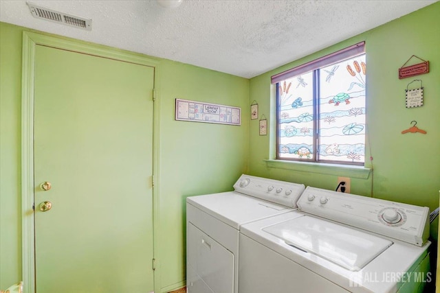 washroom with washing machine and dryer and a textured ceiling