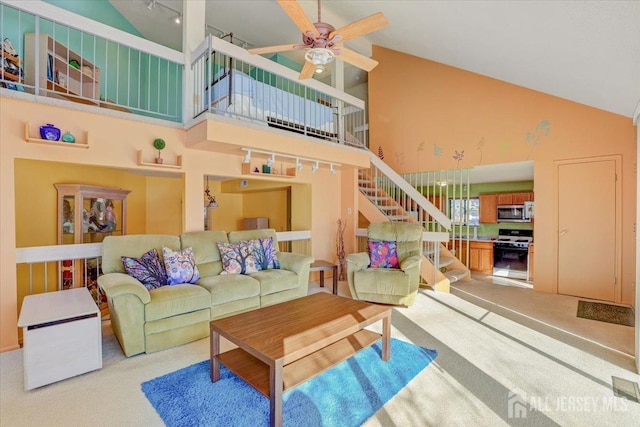 living room with high vaulted ceiling, light carpet, and ceiling fan