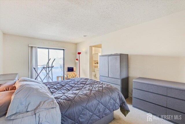 carpeted bedroom featuring access to exterior, connected bathroom, and a textured ceiling