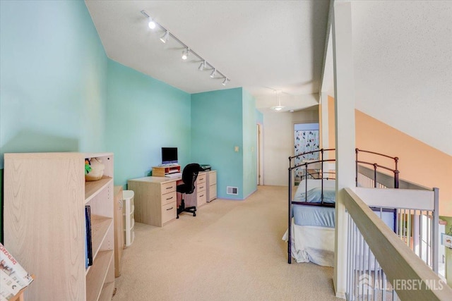 carpeted home office featuring rail lighting