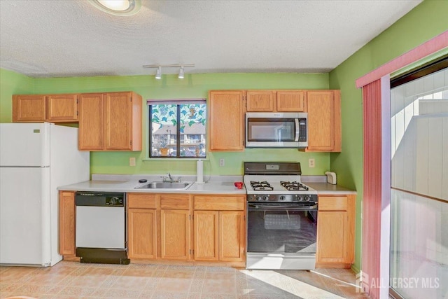 kitchen with white appliances, sink, and a textured ceiling