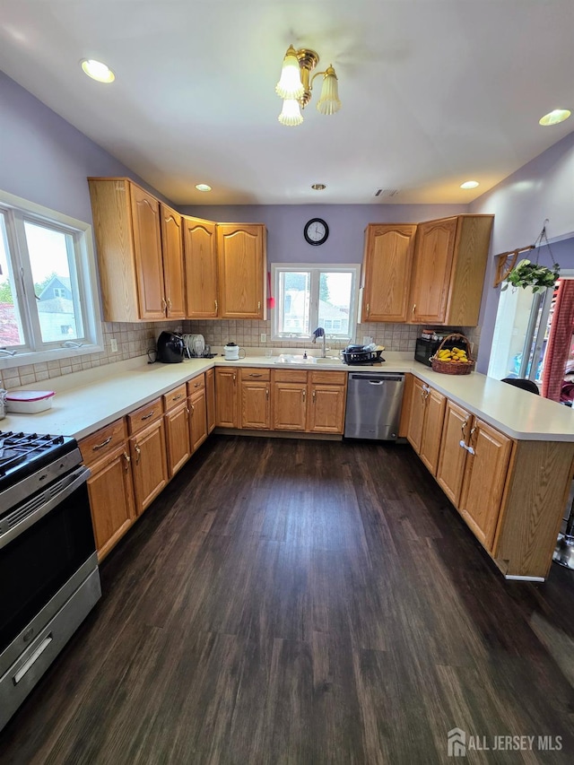 126 Holly St, Port Reading, NJ 07064 - kitchen with appliances with stainless steel finishes, a sink, a peninsula, dark wood-style flooring, and light countertops