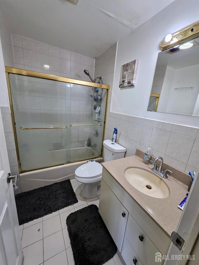 126 Holly St, Port Reading, NJ 07064 - full bath with vanity, bath / shower combo with glass door, toilet, tile patterned floors, and tile walls