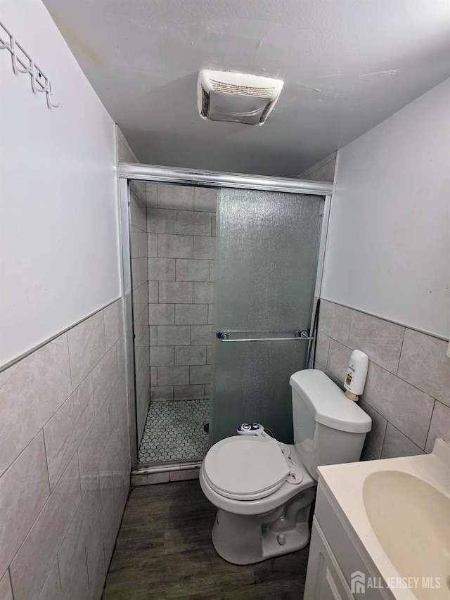 126 Holly St, Port Reading, NJ 07064 - bathroom featuring tile walls, vanity, a stall shower, wood finished floors, and wainscoting