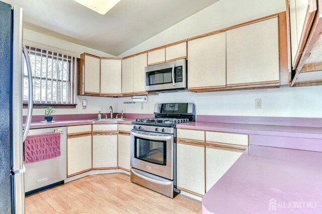 6 Schuyler Dr, Edison, NJ 08817 - kitchen featuring stainless steel appliances, lofted ceiling, a sink, light wood-type flooring, and cream cabinetry