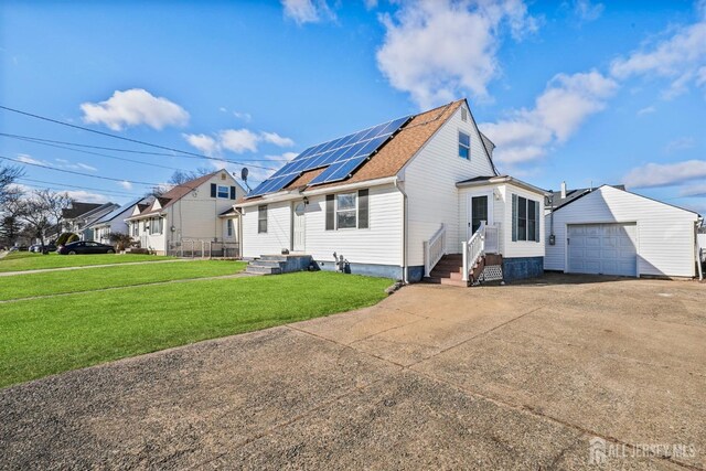 exterior space with a garage, a lawn, and solar panels