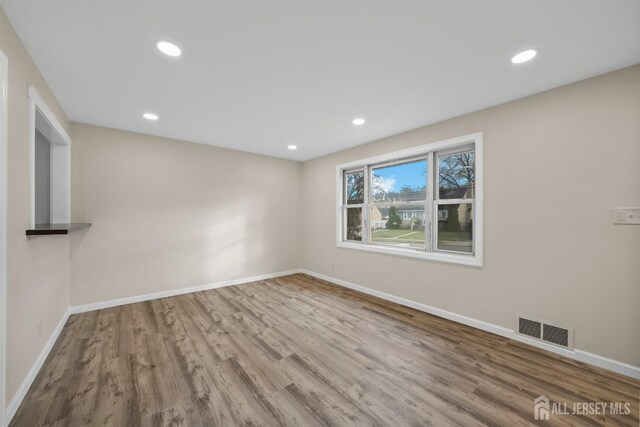 unfurnished room with hardwood / wood-style floors