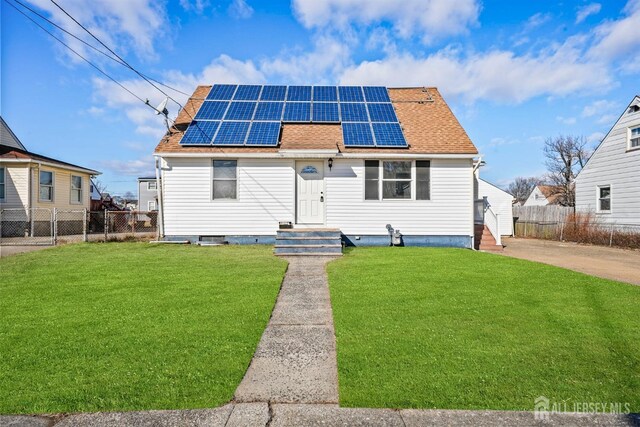 view of front of property featuring a front yard and solar panels