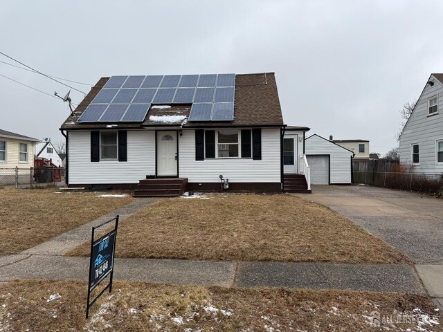 view of front of house featuring a garage, an outbuilding, and solar panels