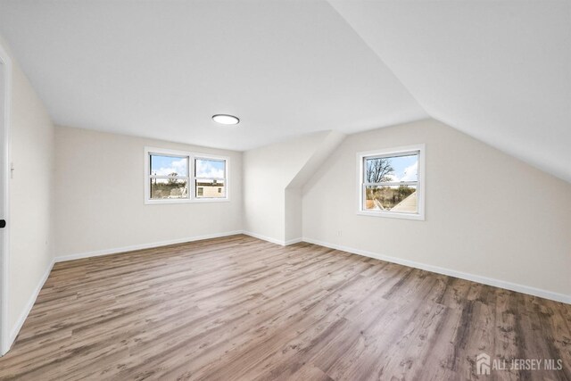 bonus room featuring vaulted ceiling and light wood-type flooring