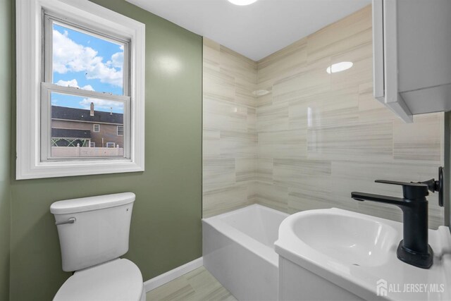 bathroom featuring toilet, sink, and a tub