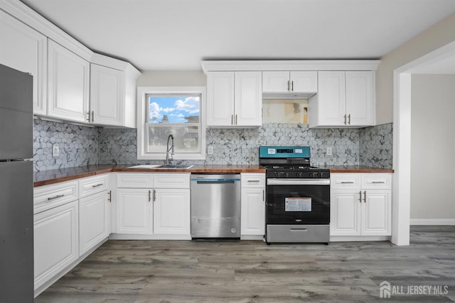 kitchen featuring white cabinetry, appliances with stainless steel finishes, sink, and light wood-type flooring