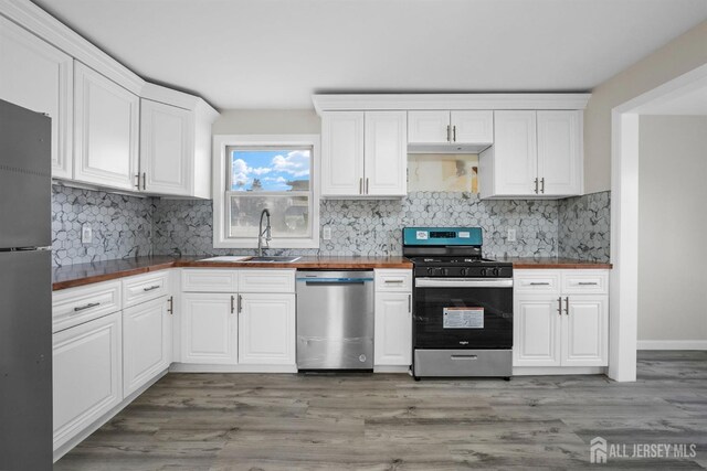 kitchen featuring white cabinetry, stainless steel appliances, sink, and light wood-type flooring