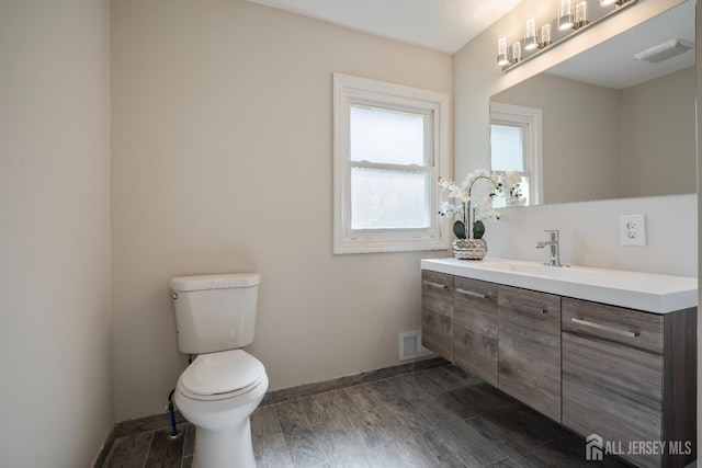 34 Hershey Rd, East Brunswick, NJ 08816 - bathroom featuring toilet, vanity, baseboards, and wood finished floors