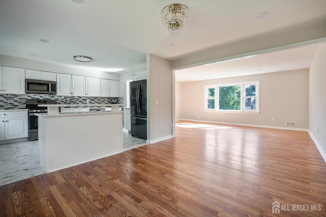 34 Hershey Rd, East Brunswick, NJ 08816 - kitchen with stainless steel appliances, open floor plan, backsplash, a kitchen island, and light countertops