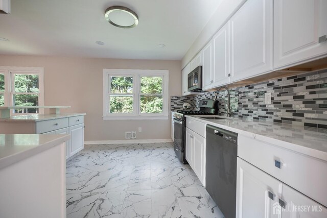 34 Hershey Rd, East Brunswick, NJ 08816 - kitchen featuring appliances with stainless steel finishes, healthy amount of natural light, white cabinets, and decorative backsplash