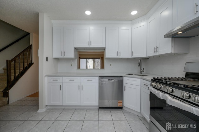 kitchen featuring stainless steel appliances, a sink, white cabinetry, light countertops, and range hood