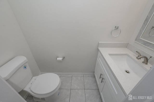 bathroom featuring baseboards, vanity, toilet, and tile patterned floors