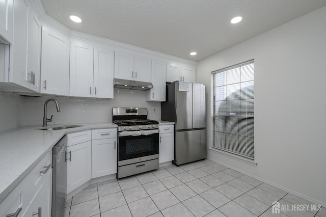 kitchen featuring stainless steel appliances, a sink, white cabinetry, and under cabinet range hood