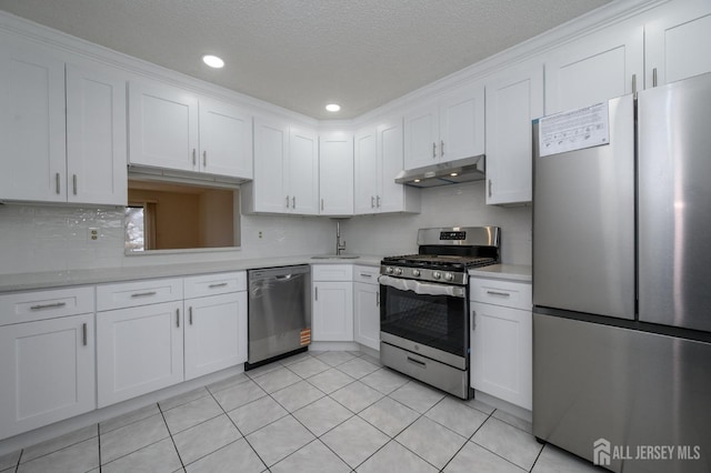 kitchen with light tile patterned flooring, under cabinet range hood, stainless steel appliances, white cabinets, and light countertops