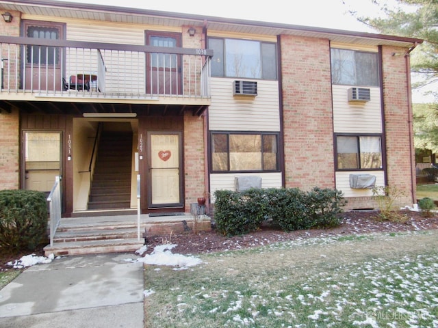 view of front facade featuring a balcony and brick siding