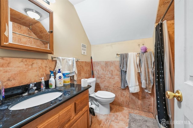 bathroom with lofted ceiling, tile walls, vanity, tile patterned floors, and toilet